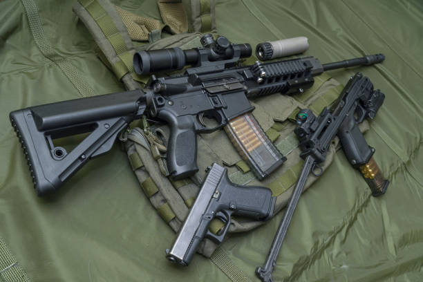 istock Tactical firearms on camouflage background, rifles and pistols 1749963995