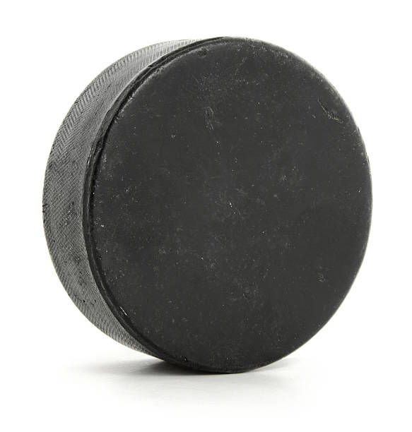 A singular hockey puck on white stock photo