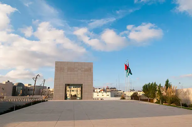 Palestinian flags fly outside the tomb of Yasser Arafat at the Palestinian Authority Presidential compound in the West Bank city of Ramallah. Arafat was for decades the symbol of the Palestinian national movement. He died in 2004 while President of the Palestinian Authority. The silhouettes of three unidentifiable honor guards are inside the building.