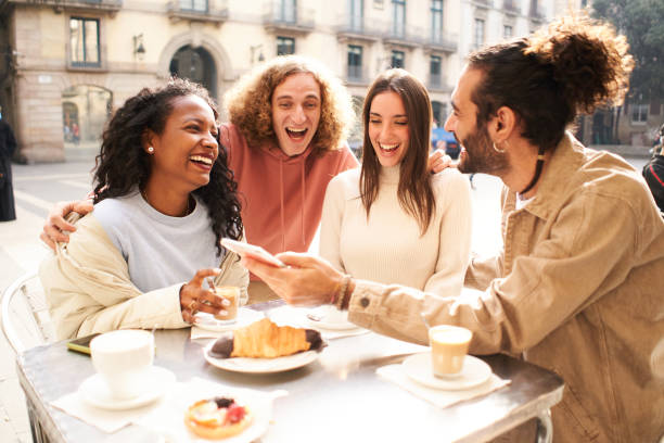 istock People group talking at coffee bar terrace watching screen phone. Friends having fun together using mobile smartphone 1749973969