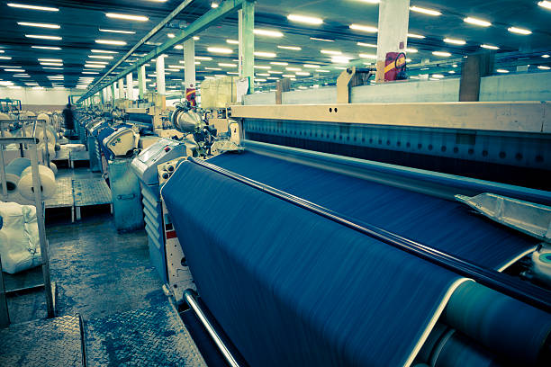 denim industrie textile, en jeans airjet métiers à tisser recouverts de tissu - textile industry loom machine textile photos et images de collection