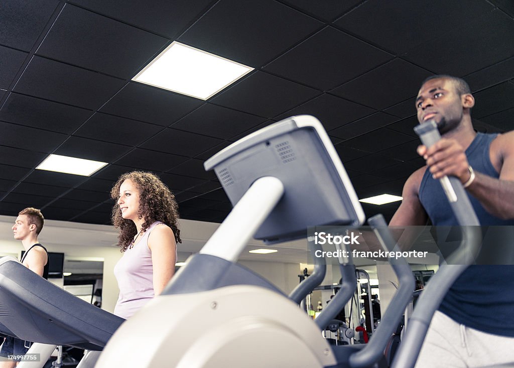 Uomo sulla macchina Cardio con tapis roulant in una palestra - Foto stock royalty-free di Abbigliamento sportivo