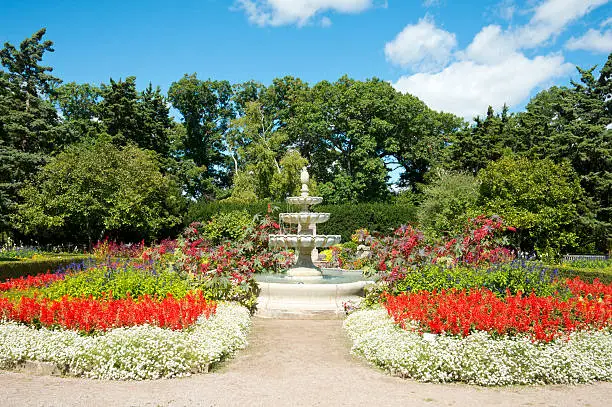 A water fountain at the Royal Botanical Garden in Burlington Ontario with flowering annuals in the later summer season.