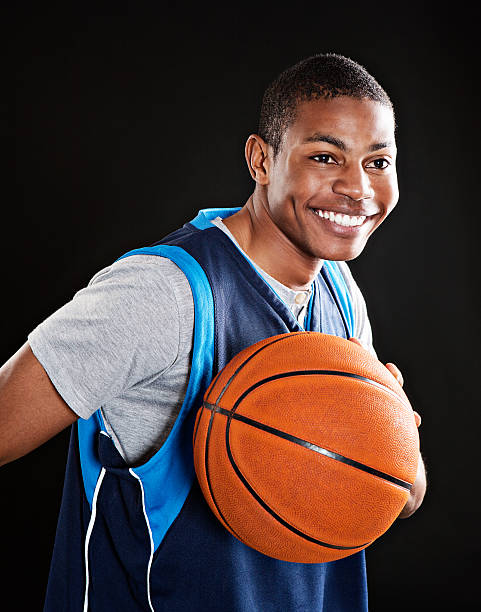 istock Cute, smiling basketball player against black 174998406