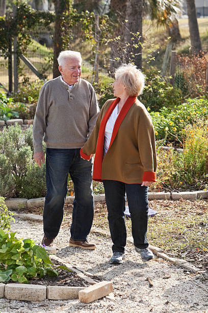 istock Senior couple holding hands, walking through garden 174998416