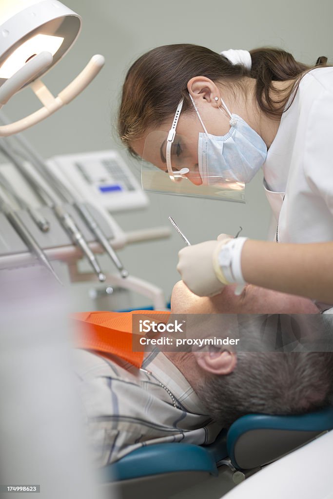 Paziente e un dentista in ufficio dentale - Foto stock royalty-free di Adulto