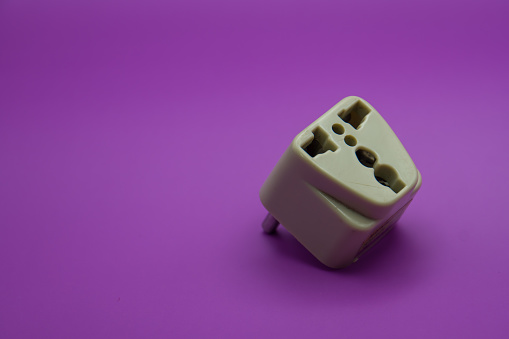 Adapter for sockets. Close up. Isolated on a purple background.