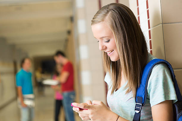 istock Pretty teenage student using her cell phone on campus 174998847
