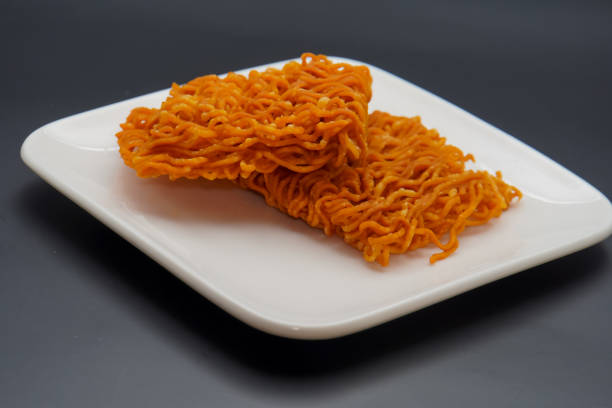 dry noodle snack ready to eat dry noodle snack ready to eat, on a plate on a black background dissert stock pictures, royalty-free photos & images