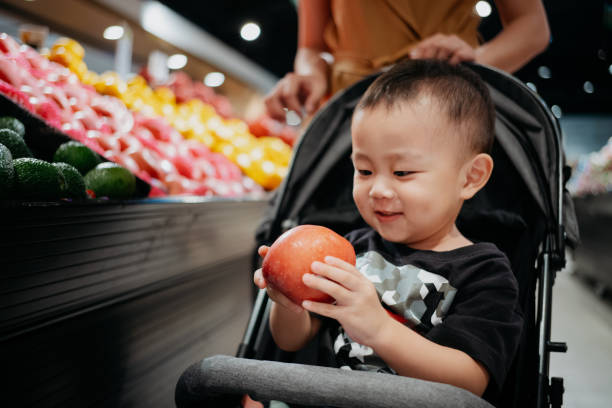 istock Happy young boy holding fresh apple in supermarket 1750002953