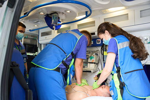 Effective cardiopulmonary resuscitation of a patient in an ambulance, paramedics doing cardiac massage