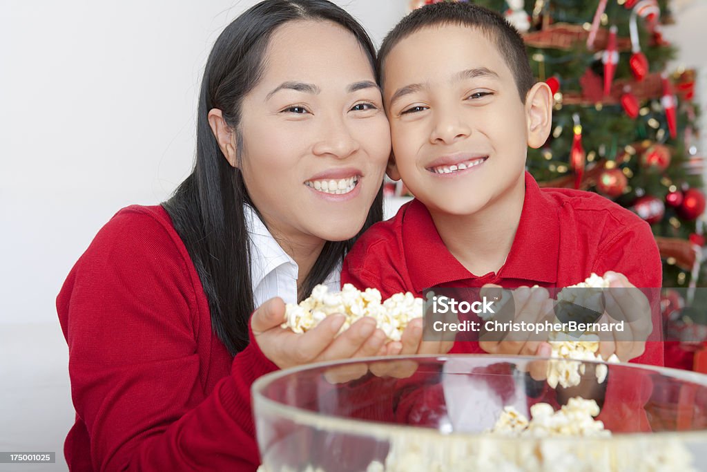 Christmas-Asia Madre e hijo stringing palomitas de maíz - Foto de stock de 25-29 años libre de derechos