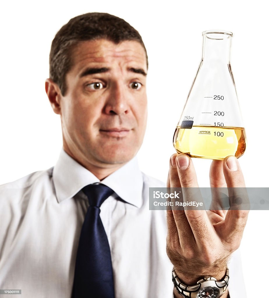 Sorprendido hombre que agarra un matraz de laboratorio con líquido amarillo - Foto de stock de 30-39 años libre de derechos