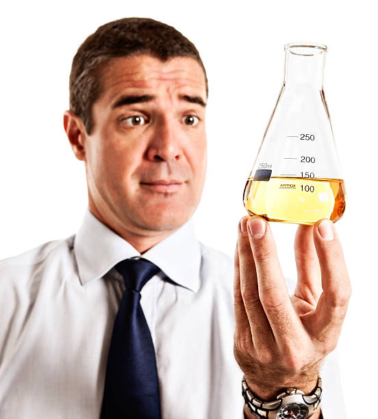 istock Surprised man holding lab flask filled with yellow fluid 175001111