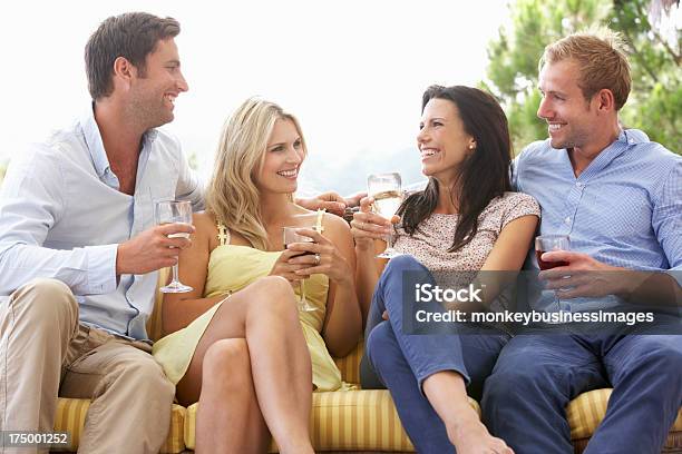 Group Of Friends Sitting On Outdoor Seat Together Stock Photo - Download Image Now - 30-39 Years, Adult, Adults Only