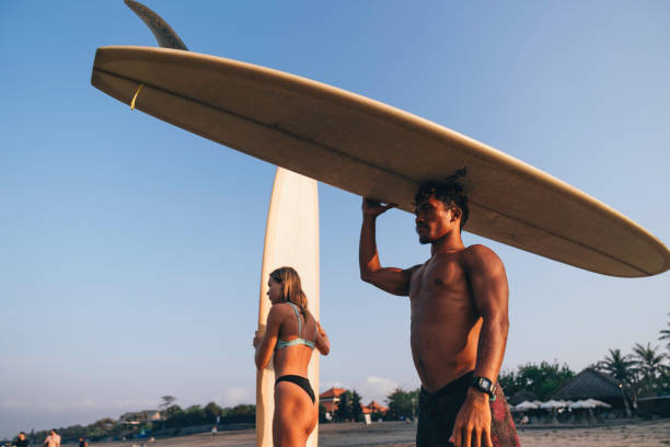 istock young couple preparing to go surfing at dawn 1750019388