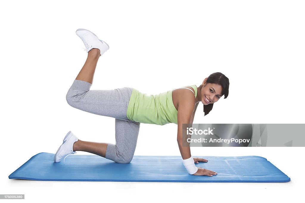 Woman Exercising Buttocks Woman Exercising Buttocks On Fitness Matt Isolated On White Active Lifestyle Stock Photo