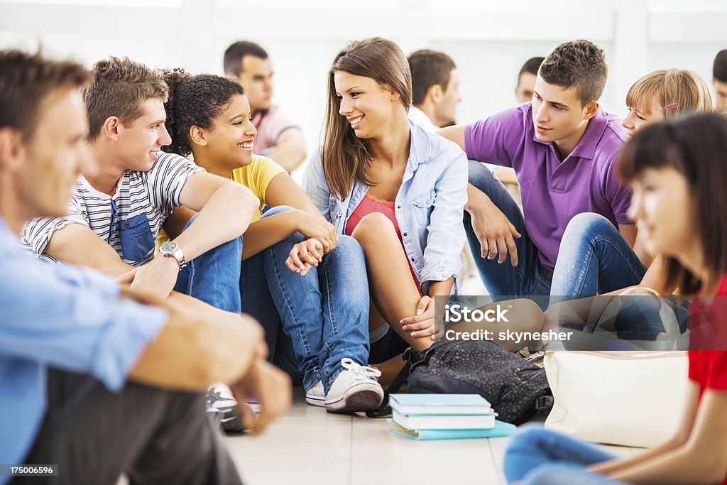 Students communicating. Cheerful group of students sitting and talking.   Adolescence Stock Photo