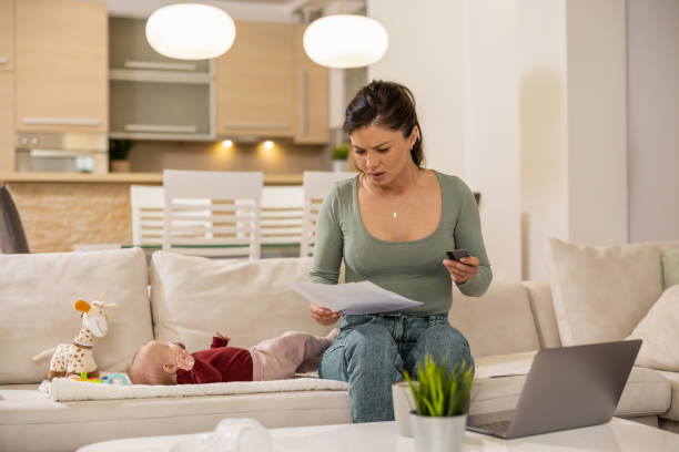 istock Young mother with a baby having financial problems,doing home budget 1750104511