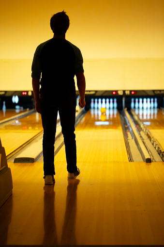 Adult Man Waiting for Ball to Hit the Pins on Bowling Alley.
