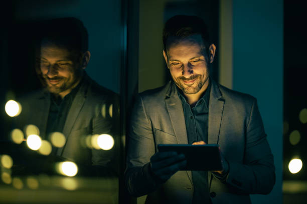 istock Smiling young businessman standing in his office and working with a digital tablet 1750114393