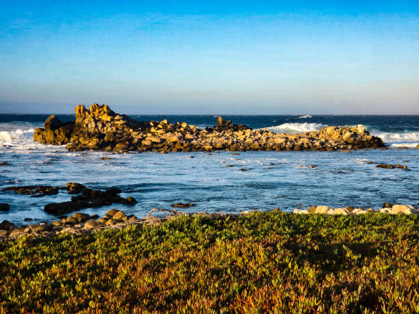 Large evening waves on a rocky California beach.