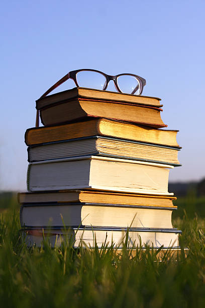 gafas en pila de libros al aire libre - bible study university old fashioned fotografías e imágenes de stock