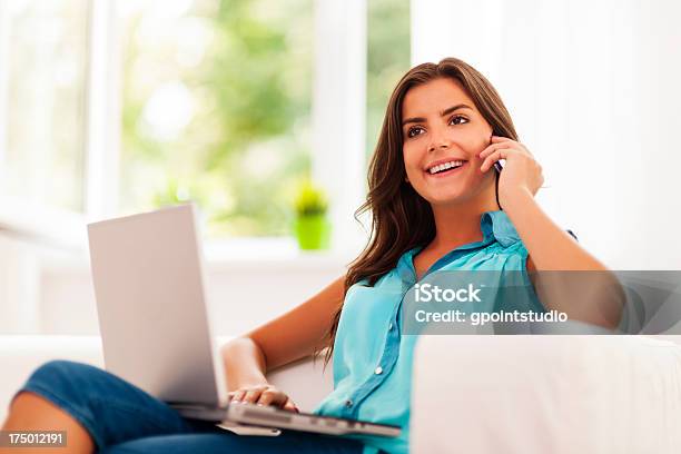 Happy Woman Paying Using Laptop And Talking On Mobile Phone Stock Photo - Download Image Now