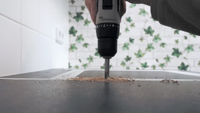 Drilling wood with a drill. Close-up of furniture assembly.