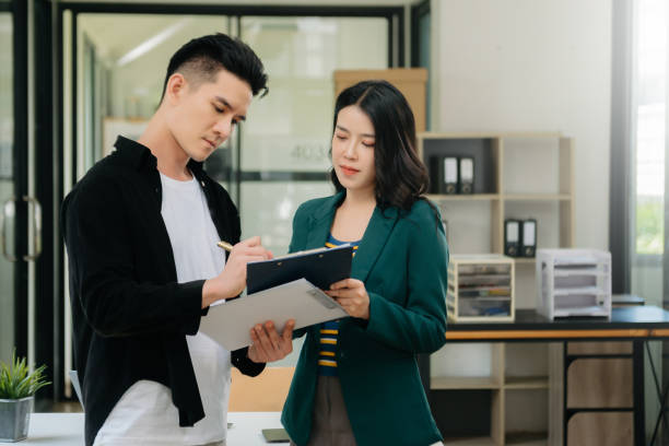istock Asian business colleague business presents and explains and using laptop and tablet. Teamwork, financial marketing team,   while sitting in modern office 1750149205