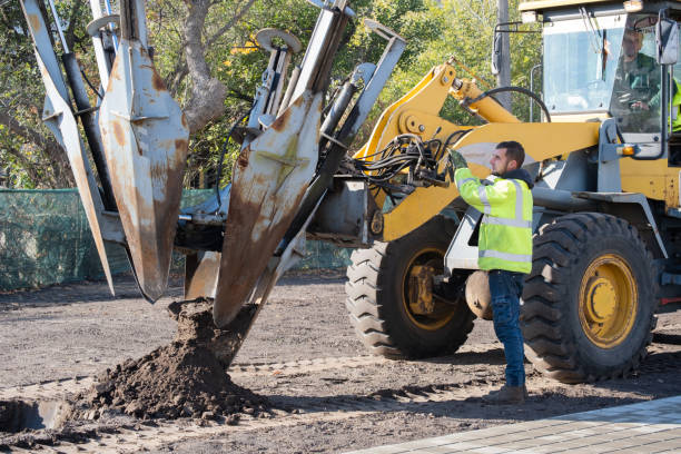 istock Male worker operates tree transplanter heavy machine. Landscaping, seasonal agricultural engineering, large trees landing machines. 1750154209