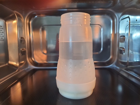 Baby bottle, isolated inside the microwave in stainless steel. Bottle suitable for sterilization in the microwave. Material free of BPA and BPS, substances that can cause harm to health.