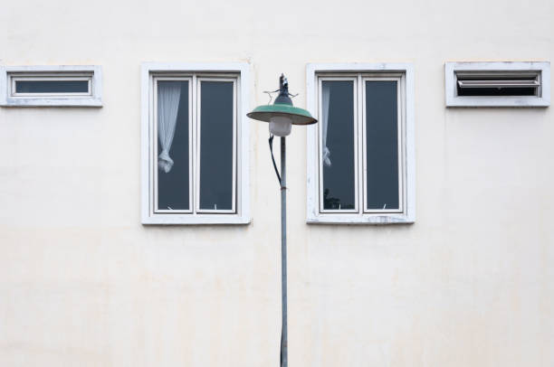 Window of an unused hotel in Yogyakarta, Indonesia. There is a lamp post next to the hotel which seems to balance the composition of the photo.