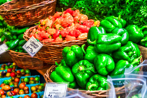 Brazilian woman buying green bell peppers