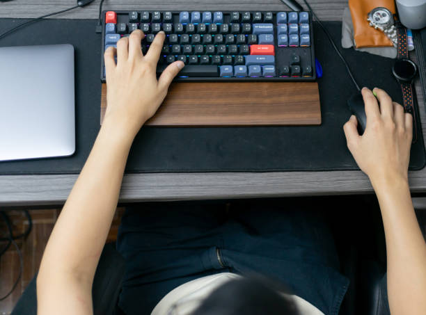 Top view. a man gamer playing video games on computer. Fun and entertainment hobby technology in a bright daylight room.