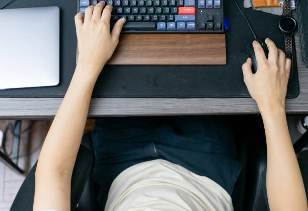 istock Top view. a man gamer playing video games on computer. Fun and entertainment hobby technology in a bright daylight room. 1750183001