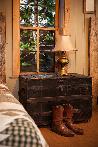istock Interiors:  Old cabin interior. Trunk nightstand.  Boots on floor. 175018313