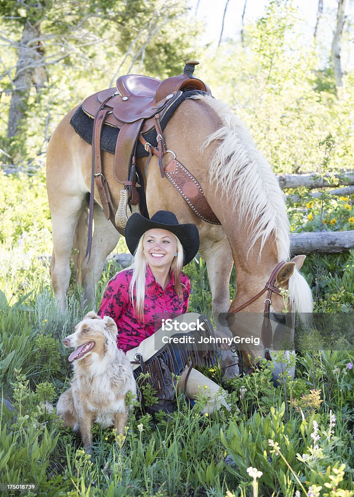 Happy Cowgirl Happy cowgirl relaxes with her horse and dog. Dog Stock Photo