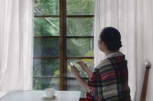 Woman Using Smart-Phone by the Window/Studio Shot