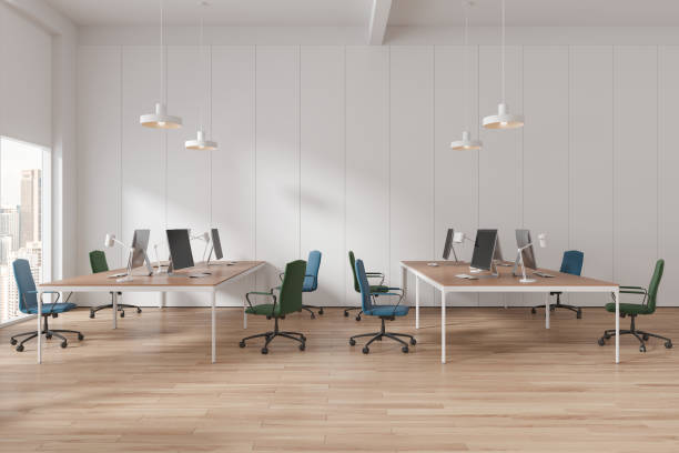 istock White office interior with pc monitors and desk near panoramic window 1750208526