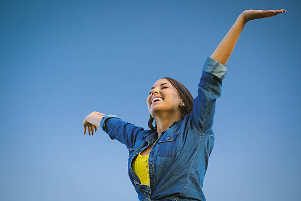istock Beautiful young woman expressing joy with her arms raised 175020893