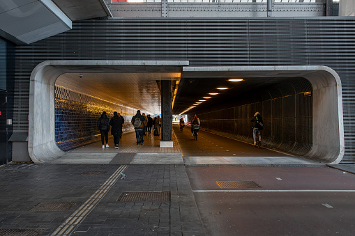 Amsterdam, Netherlands - November 23, 2021: Perspective front view of people and bicycles at an underpass tunnel in Amsterdam Netherlands November 23, 2021.