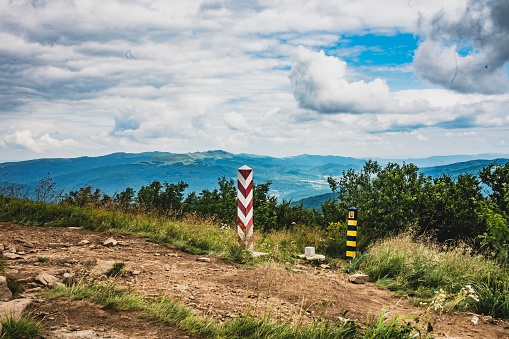 A scenic journey through Bieszczady, where a road traces the delicate boundary between Poland and Ukraine. Flanked by iconic border posts, this path symbolizes the convergence of two nations amidst the vast and serene beauty of nature.