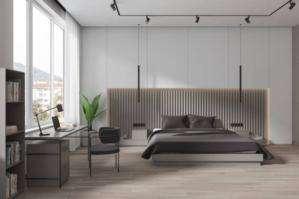 istock Stylish hotel bedroom interior with bed and workplace, decor and window 1750216878