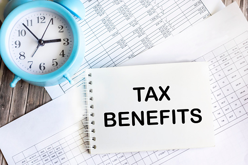On the notepad there is the inscription TAX BENEFITS on the background of accounting.