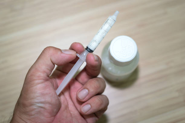 Liquid medicine in syringe for a kid. Action of a human hand is preparing liquid medicine in syringe for a kid. Healthcare and medical object, close-up and selective focus. child liquid medicine stock pictures, royalty-free photos & images