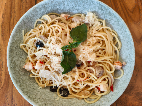 Close-up shot of Seafood Pasta Aglio Olio with parmesan cheese