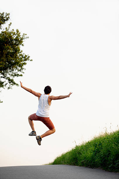 istock Young man jumping over country road 175033313