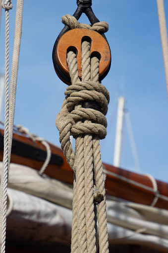 Close up of a wooden pulley with ropes of a classic sailing boat