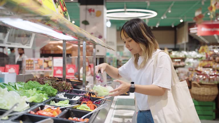 Woman picking vegetables at the salad bar